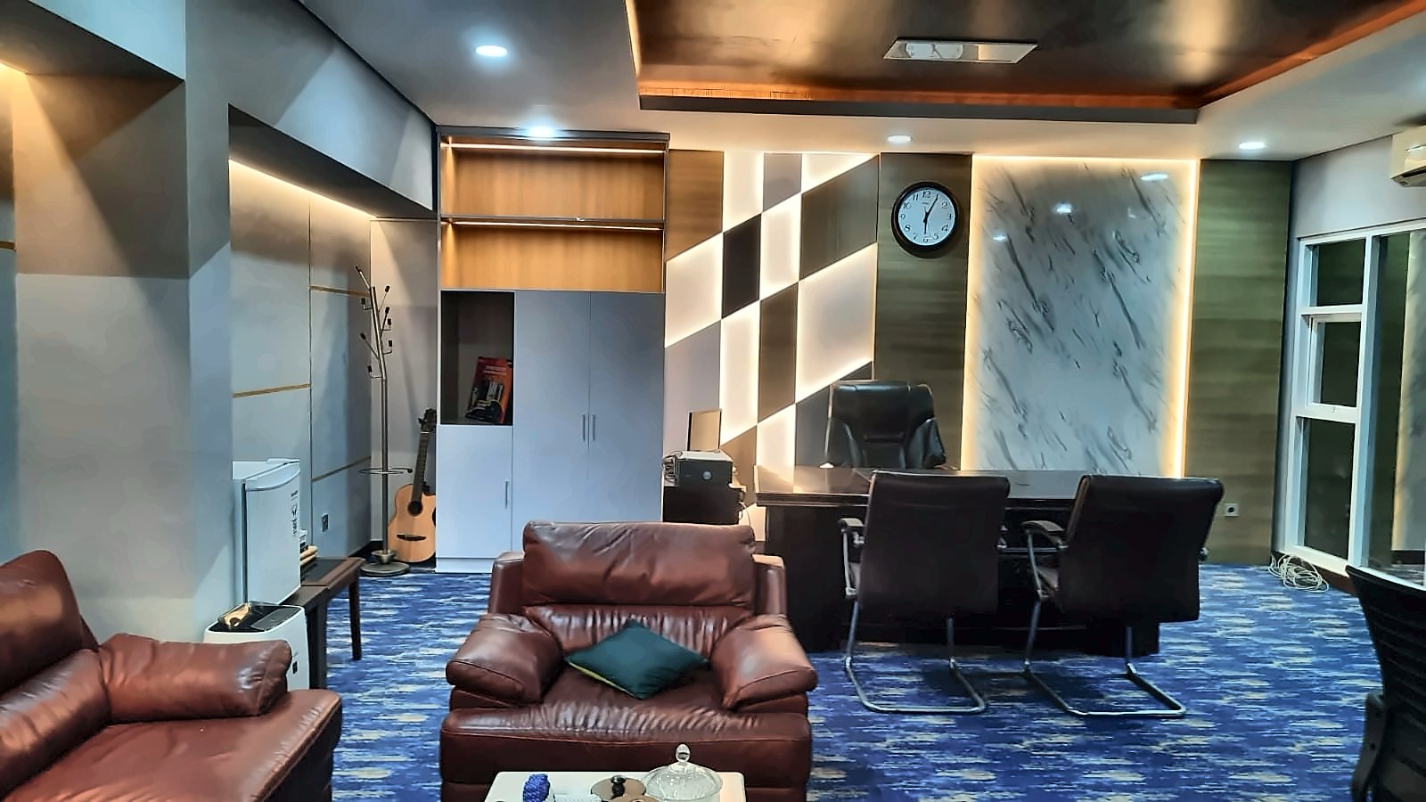Ruang Kantor: Ruang direksi dengan panel dinding bercahaya dan sofa kulit