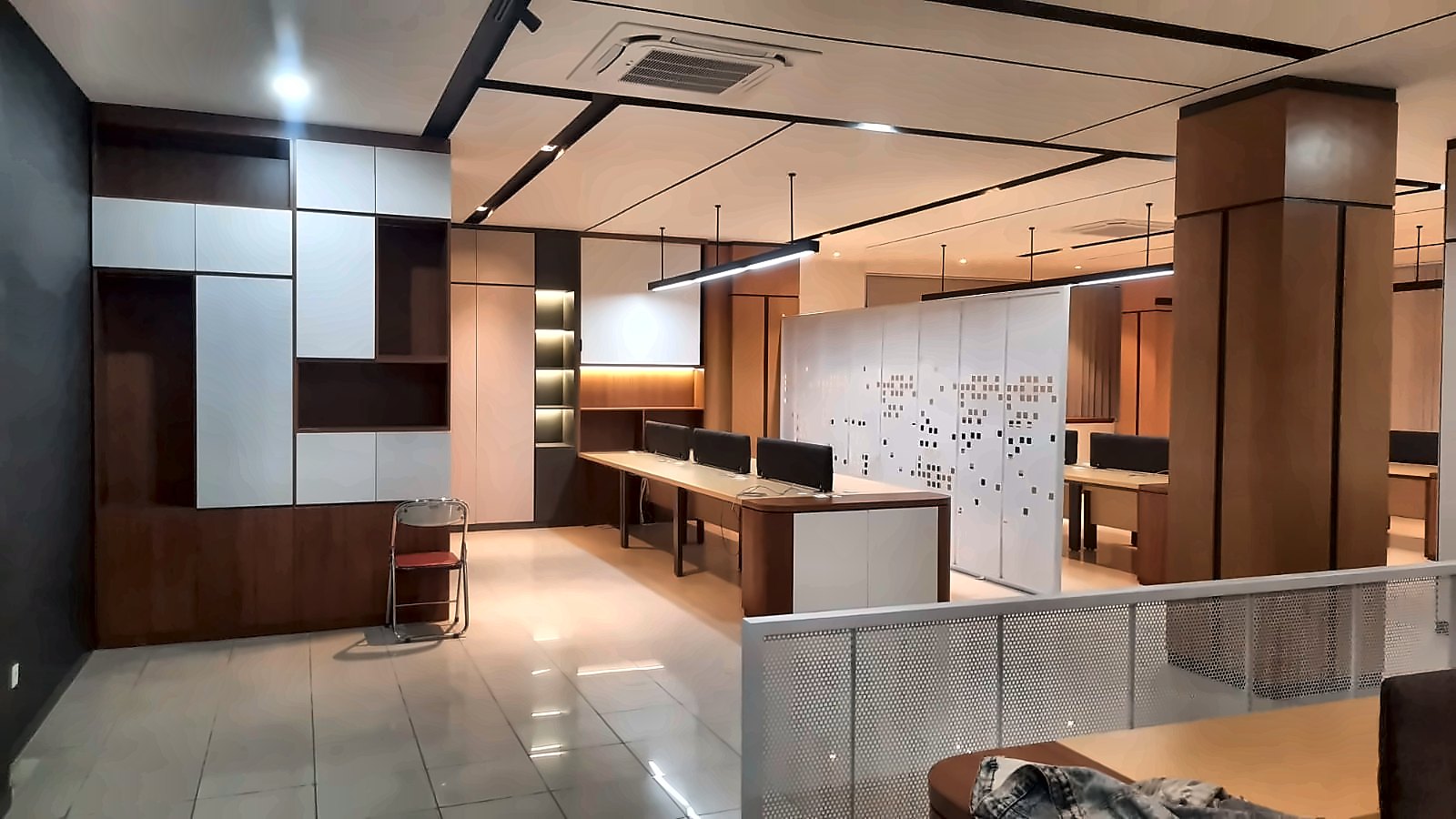 Ruang Kantor: Area kerja open plan dengan partisi berlubang dan lampu linear