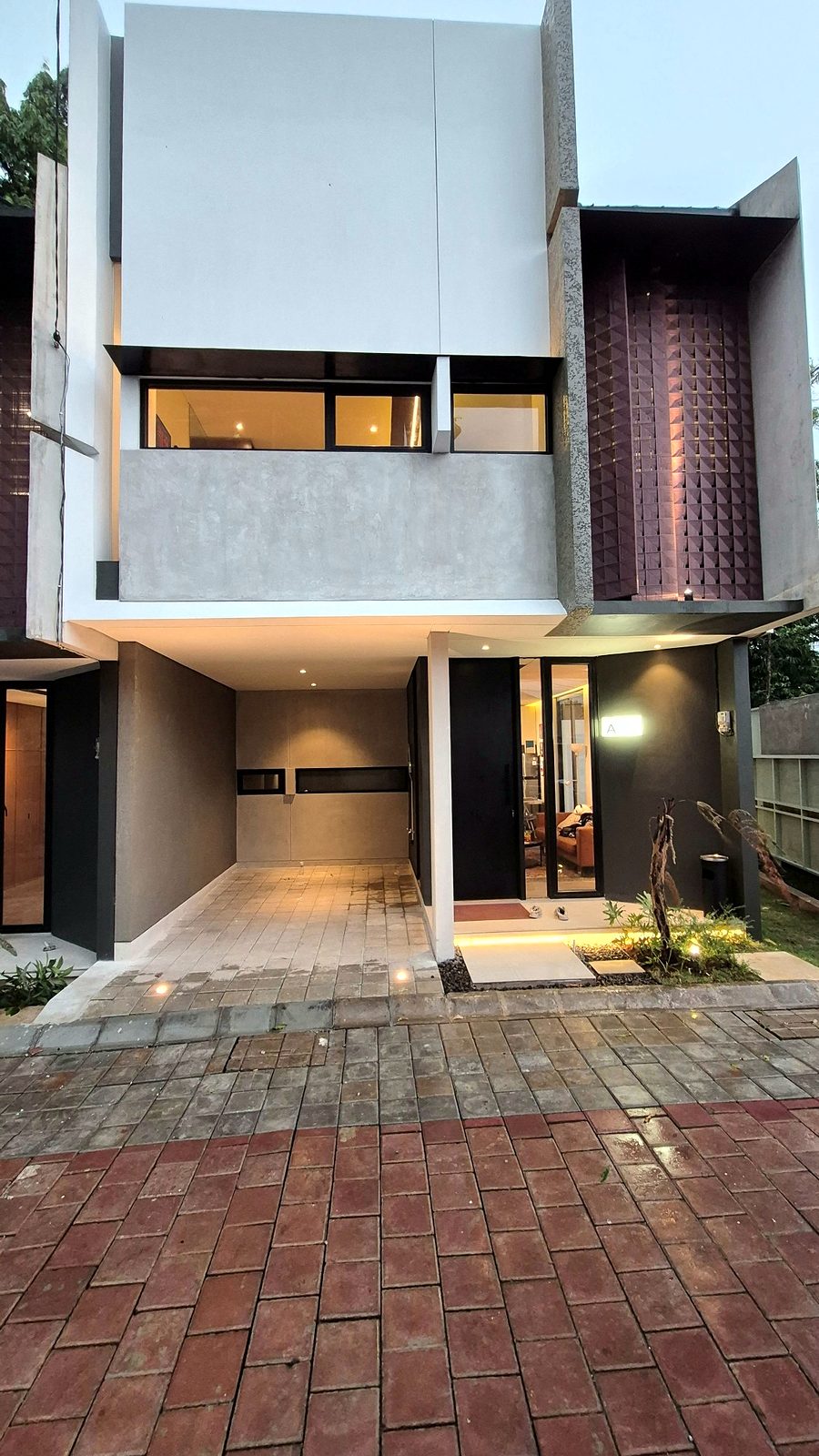 Panda Hos: fasad depan unit dengan carport, kamprot abu, dan panel rotan sintetis terakota